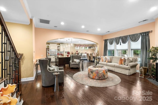 16402 Doves Canyon Ln, Charlotte, NC 28278 - living room featuring ornamental molding, arched walkways, dark wood-style floors, stairway, and a chandelier