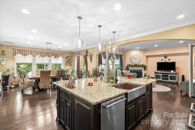 16402 Doves Canyon Ln, Charlotte, NC 28278 - kitchen featuring stainless steel dishwasher, open floor plan, arched walkways, a fireplace, and a kitchen island with sink
