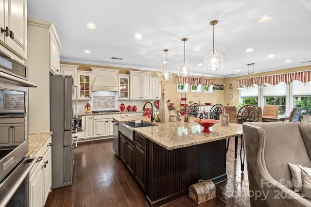 16402 Doves Canyon Ln, Charlotte, NC 28278 - kitchen with appliances with stainless steel finishes, premium range hood, open floor plan, cream cabinetry, and glass insert cabinets