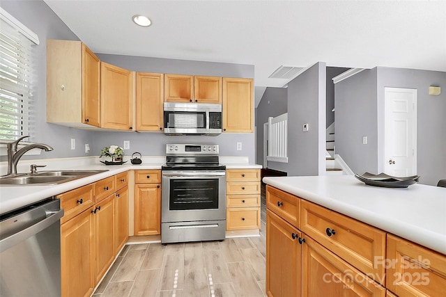 5980 Cougar Ln, Charlotte, NC 28269 - kitchen with appliances with stainless steel finishes, light countertops, recessed lighting, light brown cabinets, and light wood-type flooring