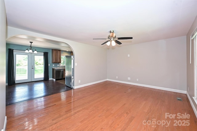 3729 Woodleaf Rd, Charlotte, NC 28205 - unfurnished living room with arched walkways, ceiling fan, wood finished floors, and french doors