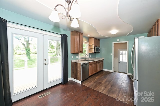 3729 Woodleaf Rd, Charlotte, NC 28205 - kitchen featuring appliances with stainless steel finishes, light countertops, dark wood-type flooring, a chandelier, and french doors