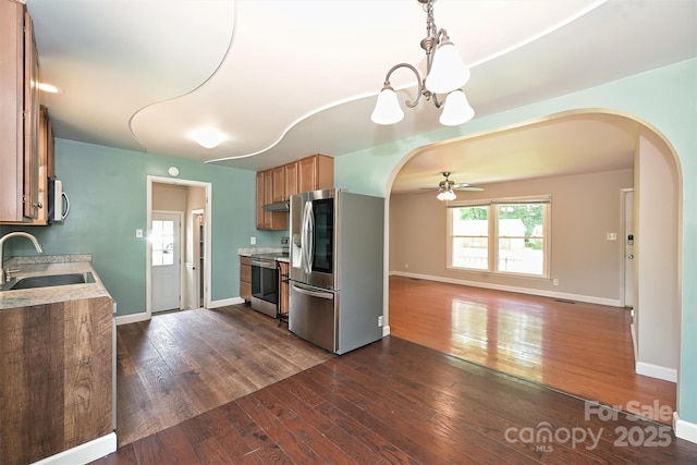 3729 Woodleaf Rd, Charlotte, NC 28205 - kitchen featuring stainless steel appliances, arched walkways, a ceiling fan, dark wood-type flooring, and light countertops