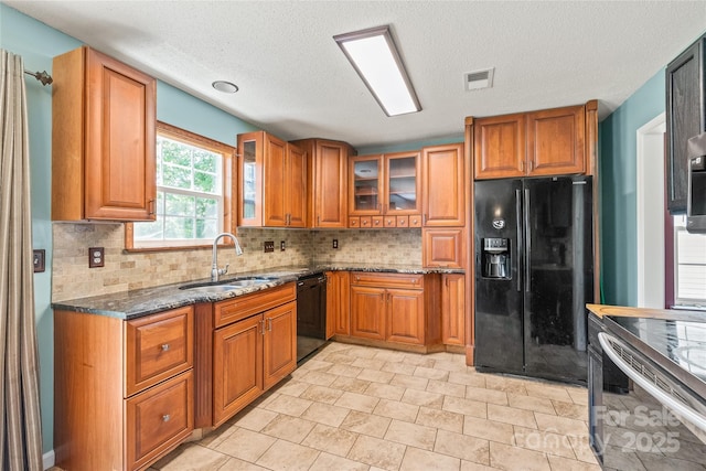 1276 Winding Path Rd, Clover, SC 29710 - kitchen with black appliances, brown cabinets, dark stone countertops, tasteful backsplash, and glass insert cabinets