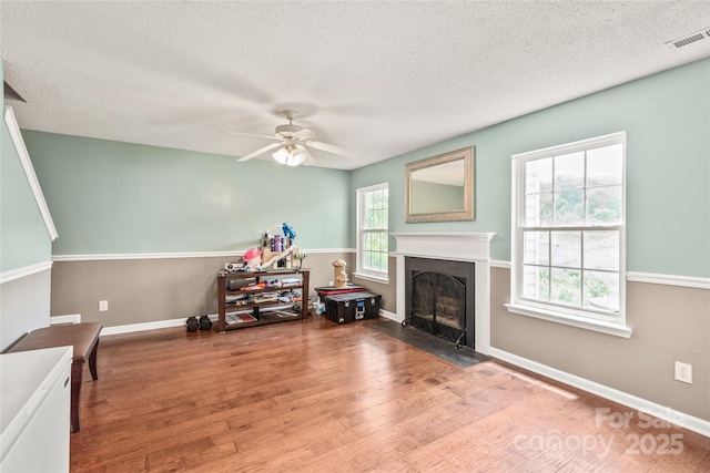 1276 Winding Path Rd, Clover, SC 29710 - living room featuring a fireplace with flush hearth, ceiling fan, wood finished floors, and a textured ceiling