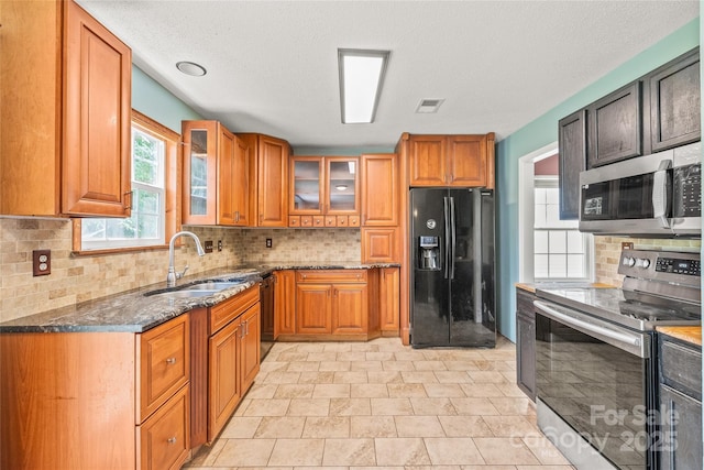 1276 Winding Path Rd, Clover, SC 29710 - kitchen featuring black appliances, dark stone countertops, decorative backsplash, and brown cabinetry