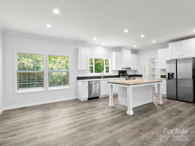 207 Walnut Branch Rd, Weaverville, NC 28787 - kitchen with stainless steel appliances, recessed lighting, ornamental molding, white cabinetry, and a kitchen breakfast bar