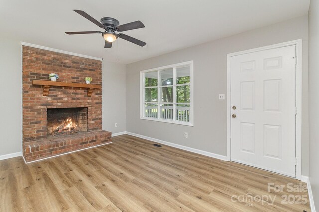 1118 Brookwood Dr, Stanley, NC 28164 - unfurnished living room featuring wood finished floors, a ceiling fan, and a brick fireplace