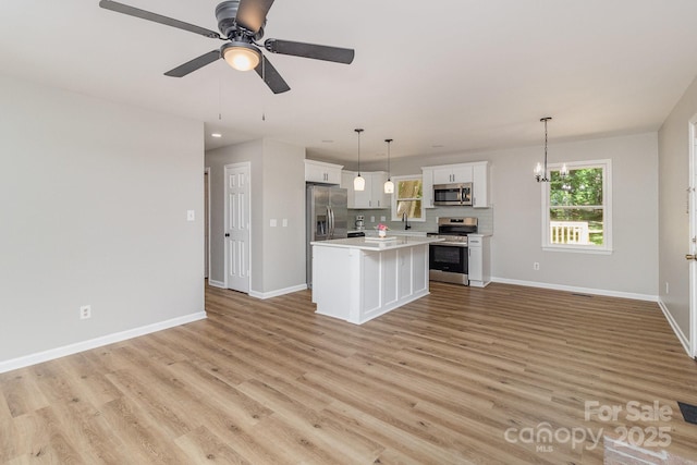 1118 Brookwood Dr, Stanley, NC 28164 - kitchen featuring appliances with stainless steel finishes, open floor plan, white cabinetry, a center island, and light countertops