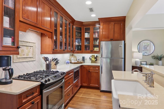 203 6th Ave W Unit 2A, Hendersonville, NC 28739 - kitchen featuring stainless steel appliances, light countertops, glass insert cabinets, backsplash, and recessed lighting