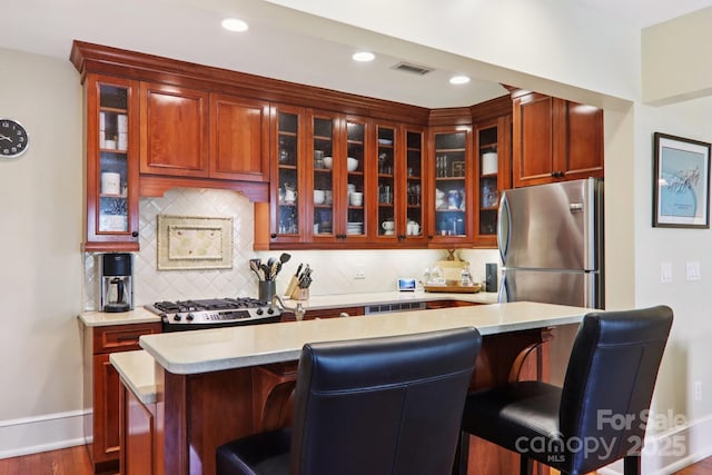 203 6th Ave W Unit 2A, Hendersonville, NC 28739 - kitchen with freestanding refrigerator, light countertops, range, tasteful backsplash, and glass insert cabinets