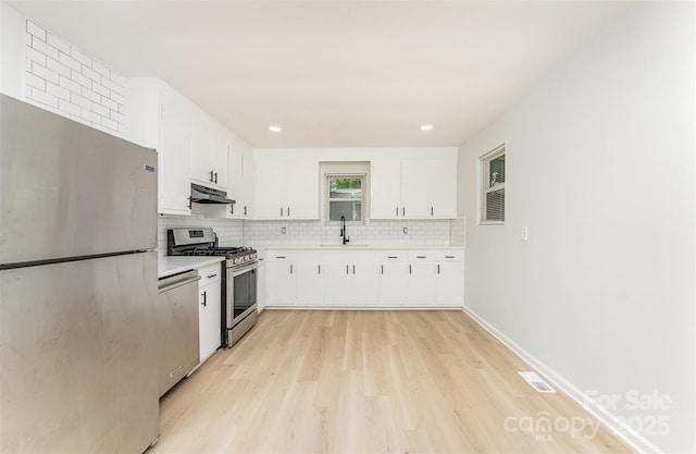 3724 Patricia Dr NW, Concord, NC 28027 - kitchen with appliances with stainless steel finishes, under cabinet range hood, light wood-style floors, light countertops, and recessed lighting