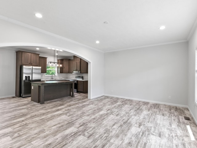 208 Walnut Branch Rd, Weaverville, NC 28787 - kitchen with stainless steel appliances, light wood finished floors, arched walkways, a kitchen island, and open floor plan