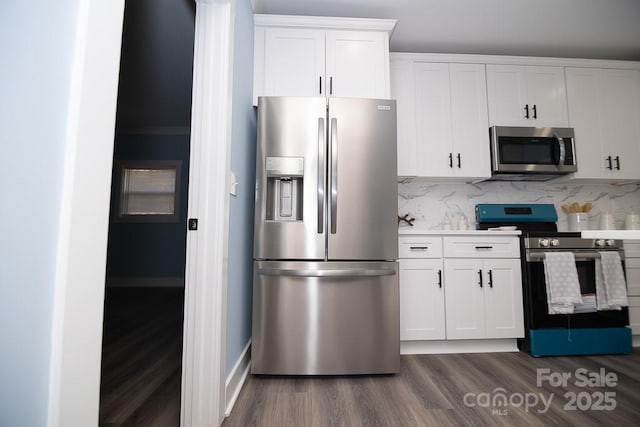 305 E Henry St, Belmont, NC 28012 - kitchen with appliances with stainless steel finishes, dark wood-style flooring, white cabinets, and tasteful backsplash