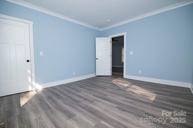 305 E Henry St, Belmont, NC 28012 - unfurnished bedroom featuring dark wood-type flooring and ornamental molding