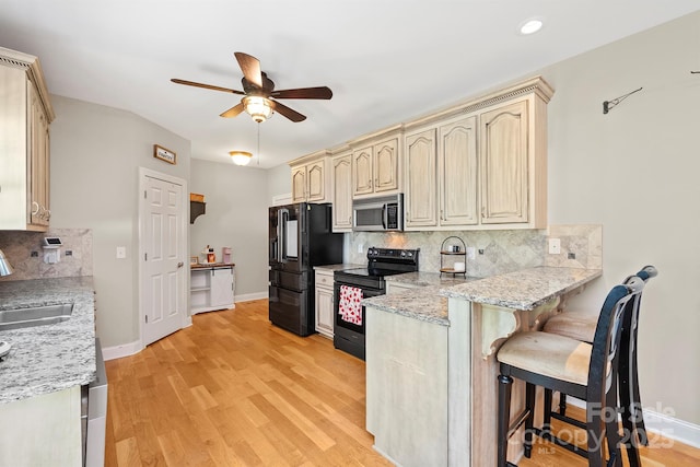 206 Taylor Cir, Granite Falls, NC 28630 - kitchen featuring black appliances, a ceiling fan, a kitchen bar, a peninsula, and backsplash