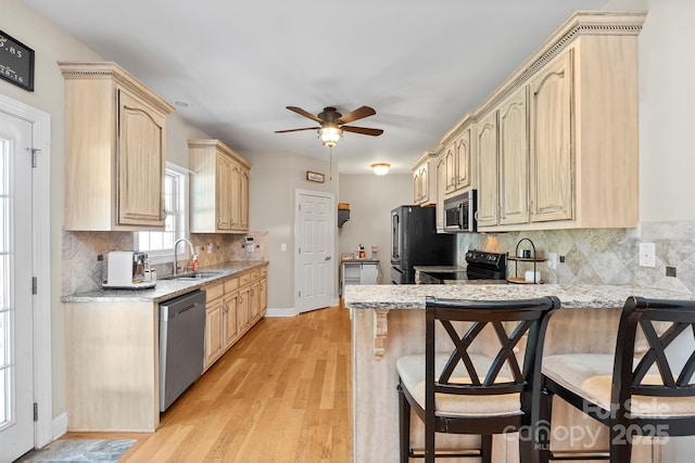 206 Taylor Cir, Granite Falls, NC 28630 - kitchen with black appliances, a peninsula, light brown cabinetry, a breakfast bar area, and a ceiling fan