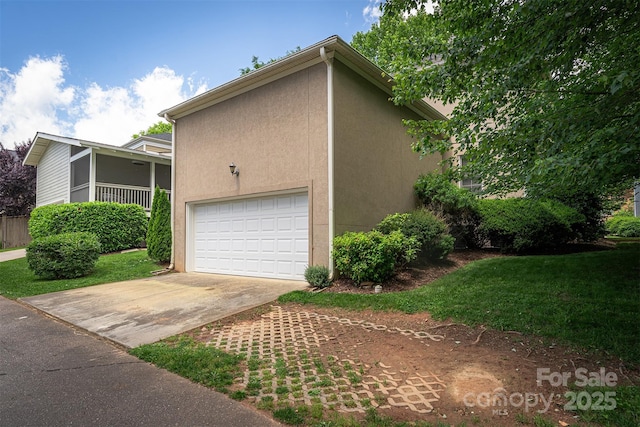 115 White Ash Dr Unit E, Asheville, NC 28801 - view of side of property featuring a garage, stucco siding, driveway, a sunroom, and a lawn