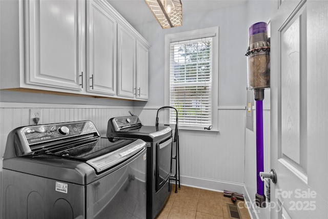 3020 Waxhaw Crossing Dr, Waxhaw, NC 28173 - laundry room with cabinet space, washing machine and dryer, light tile patterned floors, and a wainscoted wall
