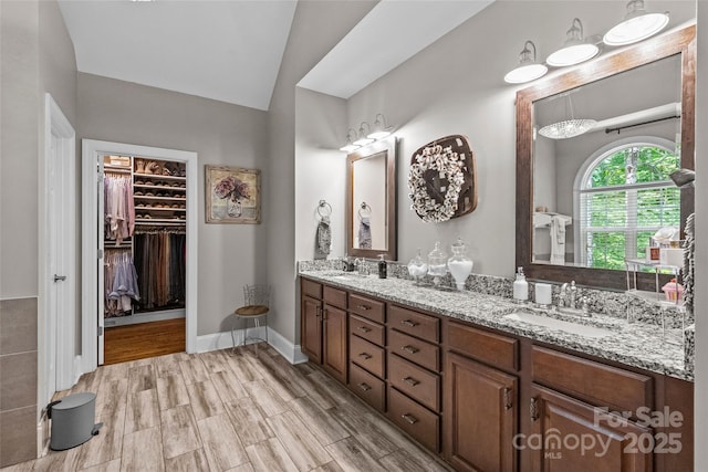 3020 Waxhaw Crossing Dr, Waxhaw, NC 28173 - full bathroom featuring double vanity, vaulted ceiling, a spacious closet, and wood finished floors