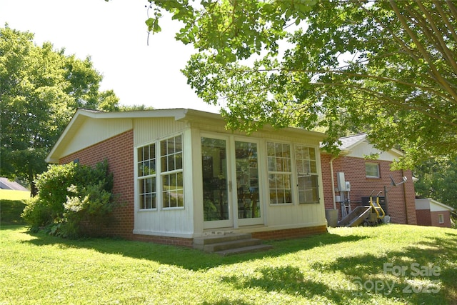 141 Azalea Dr, Connelly Springs, NC 28612 - view of property exterior with brick siding, a lawn, a sunroom, and entry steps