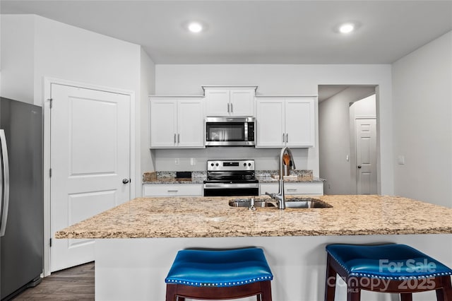 192 Culloden Dr, Mocksville, NC 27028 - kitchen featuring stainless steel appliances, dark wood-style floors, a kitchen breakfast bar, light stone countertops, and recessed lighting