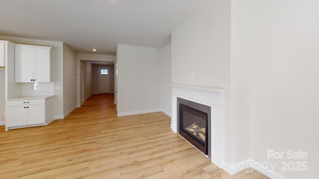 608 Banter Ln Unit 31, Cramerton, NC 28032 - unfurnished living room featuring light wood finished floors, a glass covered fireplace, and recessed lighting