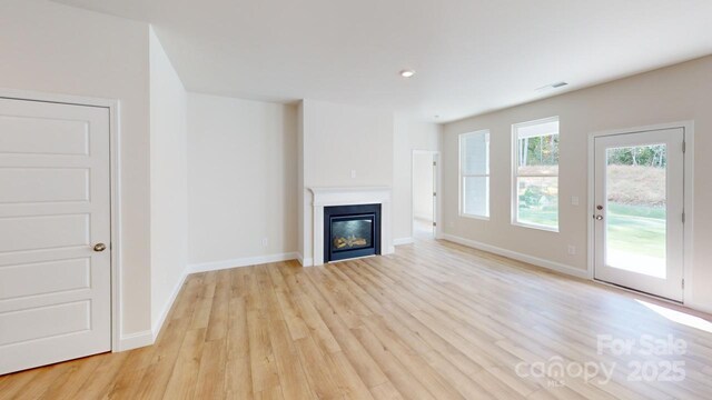 608 Banter Ln Unit 31, Cramerton, NC 28032 - unfurnished living room with light wood-style floors, a glass covered fireplace, and recessed lighting