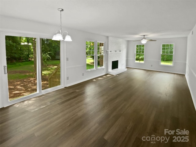 424 Mallard Dr, Pineville, NC 28134 - unfurnished living room featuring dark wood finished floors, a chandelier, ceiling fan, and a fireplace