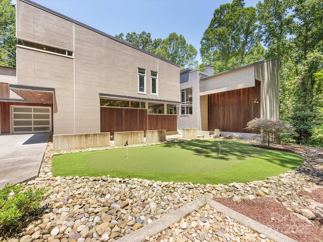 3306 Nancy Creek Rd, Charlotte, NC 28270 - back of property with a putting green, concrete driveway, and an attached garage