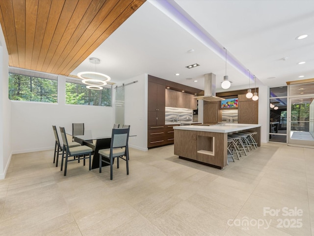 3306 Nancy Creek Rd, Charlotte, NC 28270 - kitchen with modern cabinets, light countertops, island range hood, a breakfast bar area, and a center island with sink