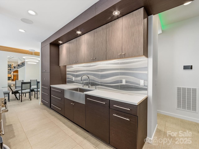 3306 Nancy Creek Rd, Charlotte, NC 28270 - kitchen with light tile patterned flooring, light countertops, decorative backsplash, recessed lighting, and dark brown cabinetry