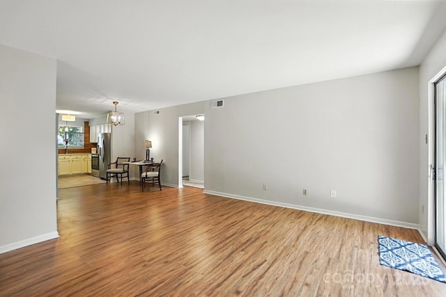 3020 Heathstead Pl Unit A, Charlotte, NC 28210 - unfurnished living room featuring a chandelier and wood finished floors