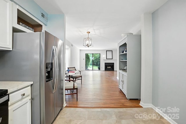 3020 Heathstead Pl Unit A, Charlotte, NC 28210 - kitchen featuring stainless steel fridge, a chandelier, white cabinets, and light wood-type flooring