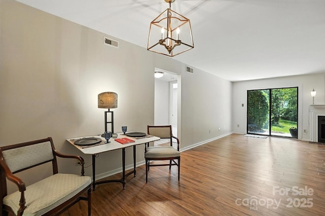 3020 Heathstead Pl Unit A, Charlotte, NC 28210 - dining space with wood finished floors, a chandelier, and a fireplace