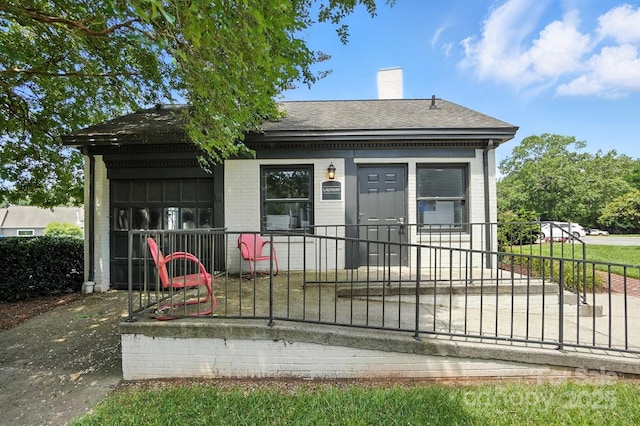 3020 Heathstead Pl Unit A, Charlotte, NC 28210 - back of property featuring roof with shingles, a chimney, brick siding, and covered porch