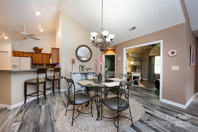 6811 Ledgestone Pl, Charlotte, NC 28227 - dining room featuring dark wood-style floors, ceiling fan, a chandelier, and high vaulted ceiling