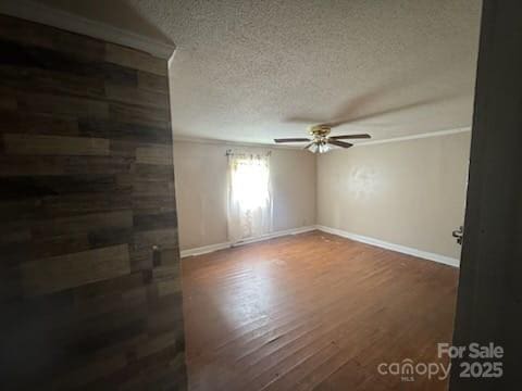 127 Hill St, Mooresboro, NC 28114 - spare room featuring a textured ceiling, ceiling fan, wood finished floors, and crown molding