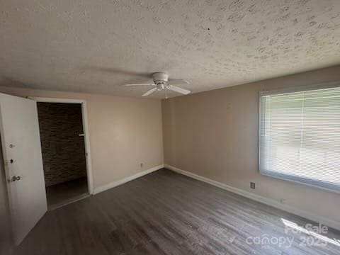 127 Hill St, Mooresboro, NC 28114 - unfurnished bedroom featuring wood finished floors, a textured ceiling, and ceiling fan
