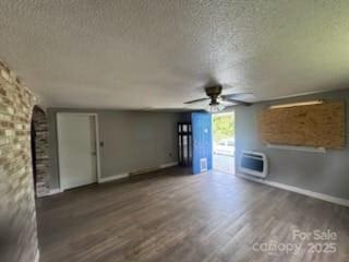 127 Hill St, Mooresboro, NC 28114 - unfurnished living room featuring a textured ceiling, ceiling fan, heating unit, and wood finished floors