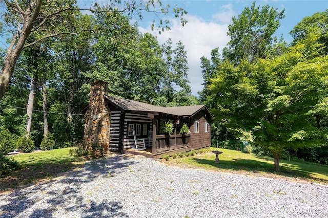 225 Wilderness Rd, Tryon, NC 28782 - view of front facade with a chimney, a deck, and a front yard