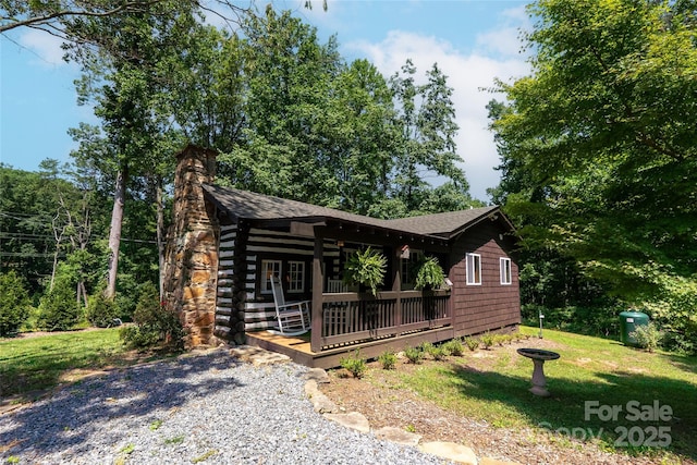 225 Wilderness Rd, Tryon, NC 28782 - view of front of property with a chimney, roof with shingles, and a front lawn