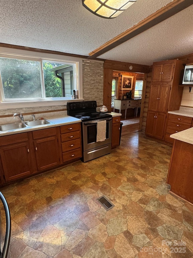 19 Timbers Edge Ln Unit 23, Fairview, NC 28730 - kitchen with stainless steel electric stove, a textured ceiling, brown cabinets, and light countertops