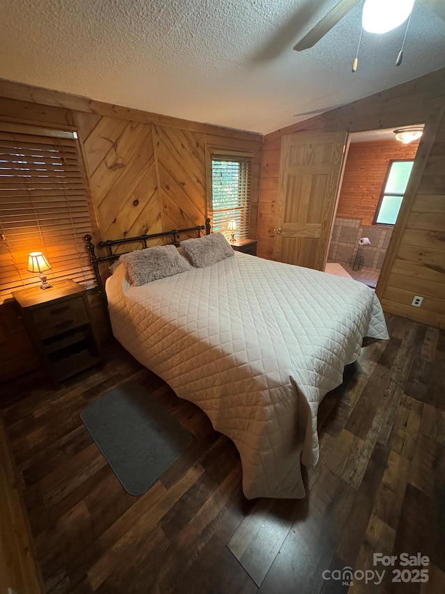 19 Timbers Edge Ln Unit 23, Fairview, NC 28730 - bedroom featuring wood walls, vaulted ceiling, dark wood-style floors, multiple windows, and a textured ceiling