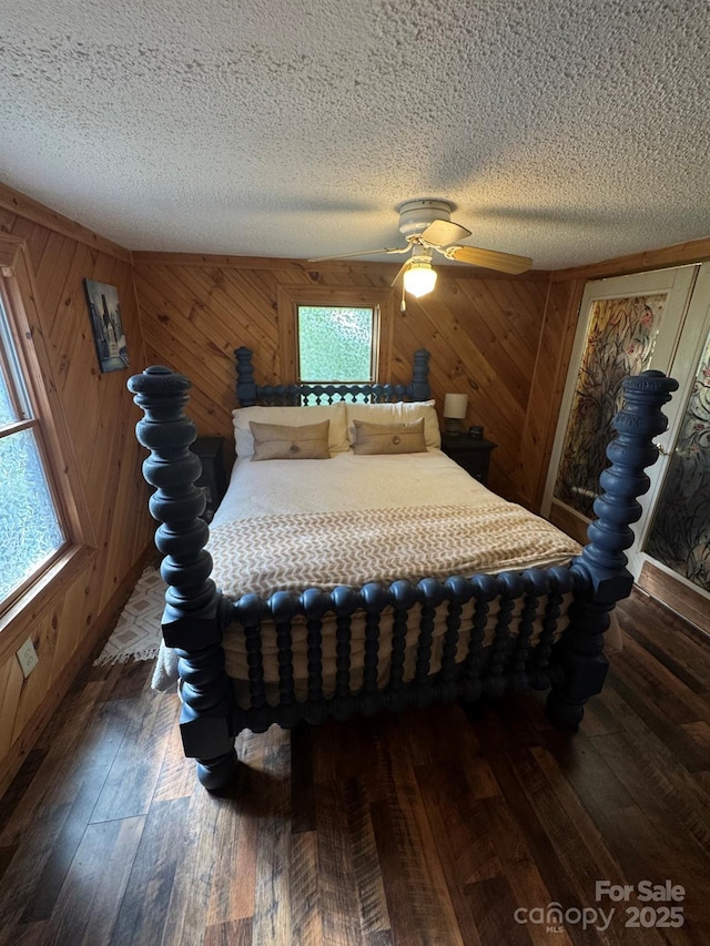 19 Timbers Edge Ln Unit 23, Fairview, NC 28730 - bedroom with a textured ceiling, dark wood-type flooring, wood walls, and a ceiling fan