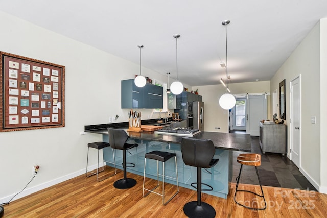 84 W St, Weaverville, NC 28787 - kitchen featuring dark countertops, a peninsula, a breakfast bar, and dark wood-style flooring