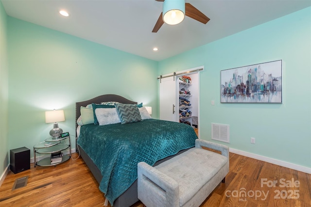 84 W St, Weaverville, NC 28787 - bedroom with a barn door, wood finished floors, a walk in closet, a ceiling fan, and recessed lighting