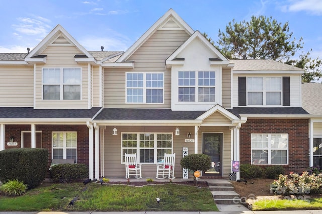 11023 Kinston Ridge Pl, Charlotte, NC 28273 - townhome / multi-family property with a porch, brick siding, and roof with shingles