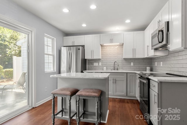 11023 Kinston Ridge Pl, Charlotte, NC 28273 - kitchen with stainless steel appliances, a breakfast bar, a center island, tasteful backsplash, and recessed lighting