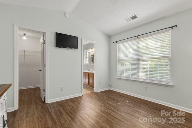 11023 Kinston Ridge Pl, Charlotte, NC 28273 - unfurnished bedroom with a spacious closet, lofted ceiling, wood finished floors, a closet, and connected bathroom